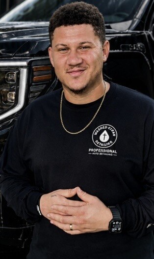 Owner of Washed Clean Detailing standing in front of a detailed truck